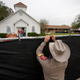 A Texas state trooper helps erect a fence around the site of the shooting at the First Baptist Church of Sutherland Springs, Texas, on Nov. 9, 2017